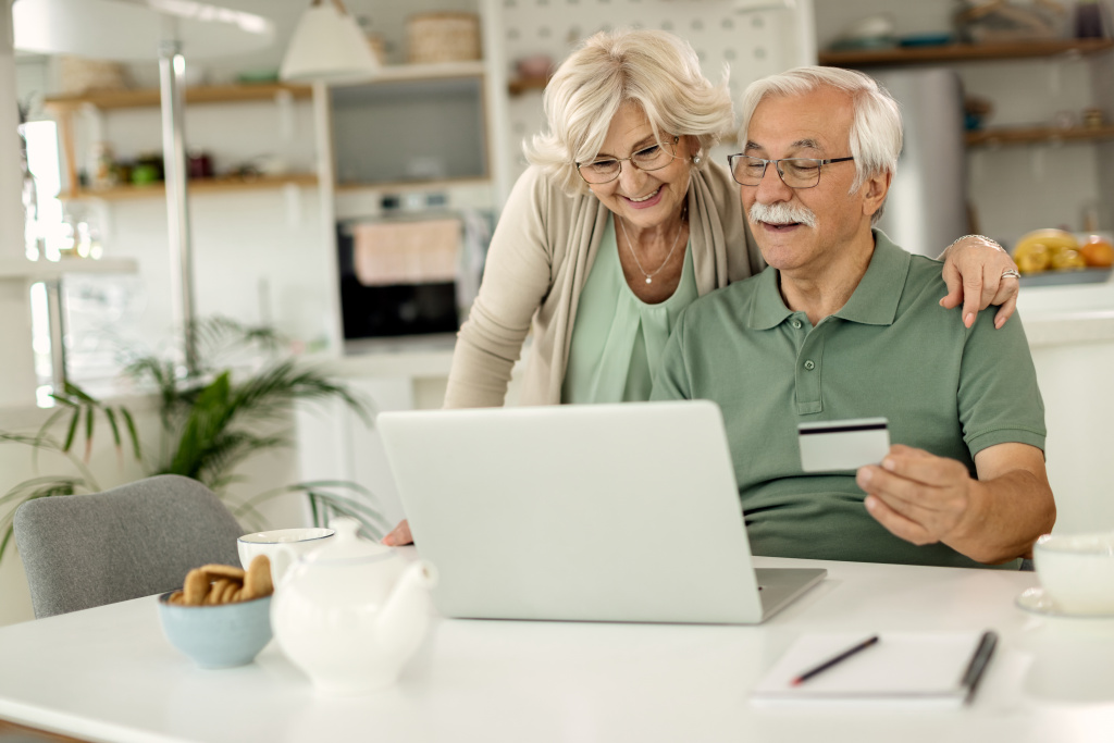 happy-mature-couple-using-laptop-credit-card-while-home-shopping.jpg