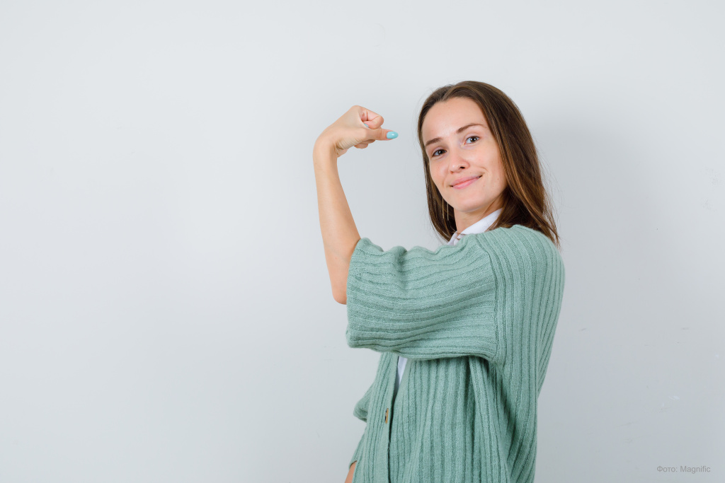 young-lady-showing-muscles-arm-shirt-cardigan-looking-pleased-front-view (1).jpg