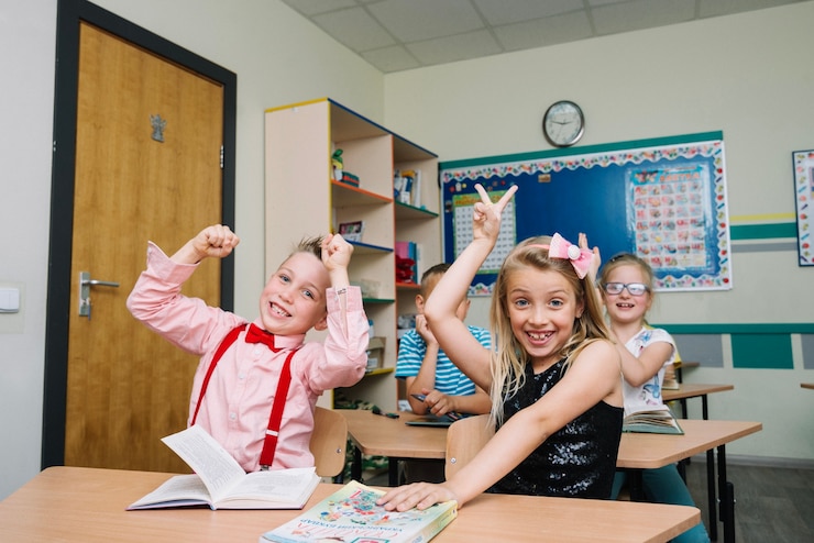 schoolchildren-sitting-desks-posing_23-2147663557.jpg