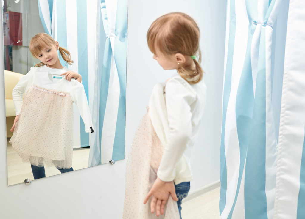 girl-choosing-trying-dress-mall-looking-mirror.jpg